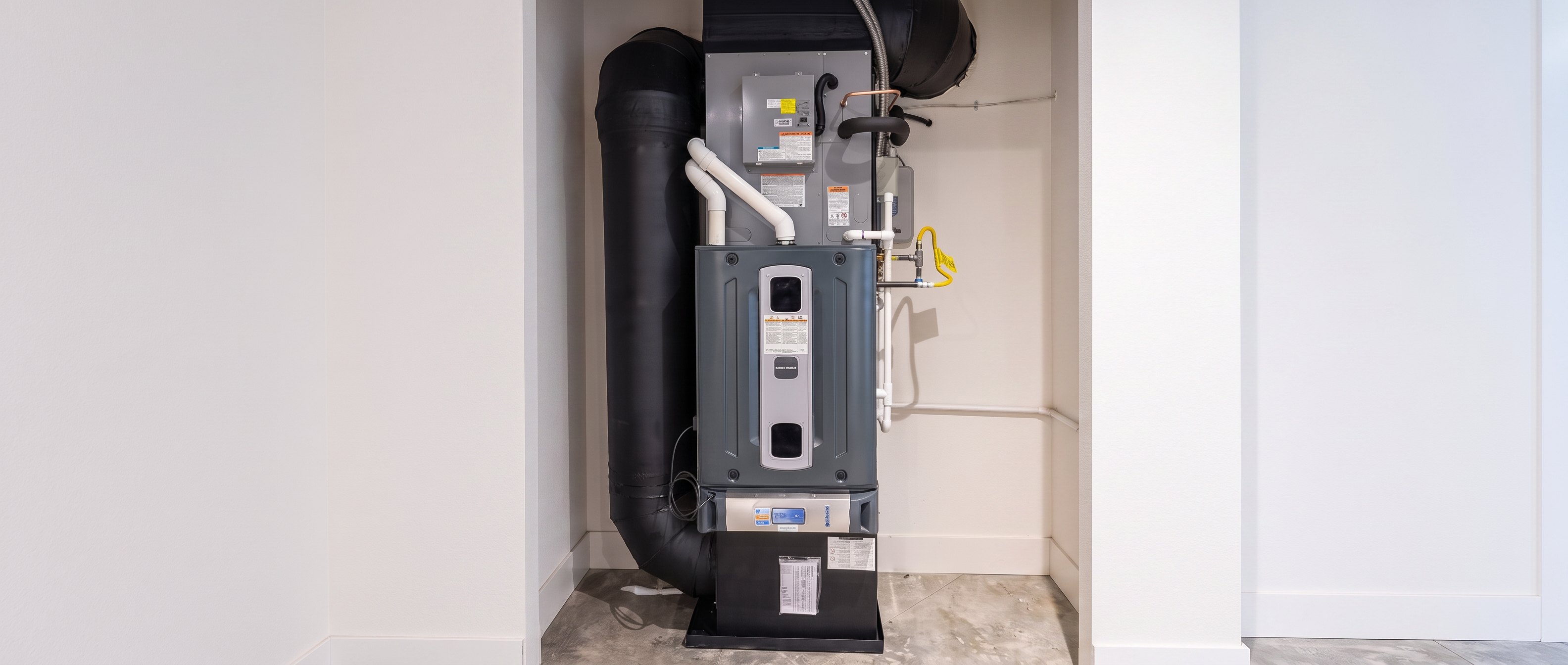 Gas furnace with new venting and gas line against clean drywall after a Pacific Peak install
