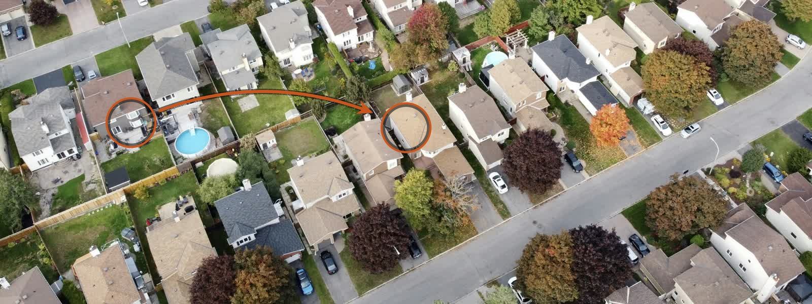 Aerial view of a neighborhood, with an arrow drawn from one house to a neighbor's house