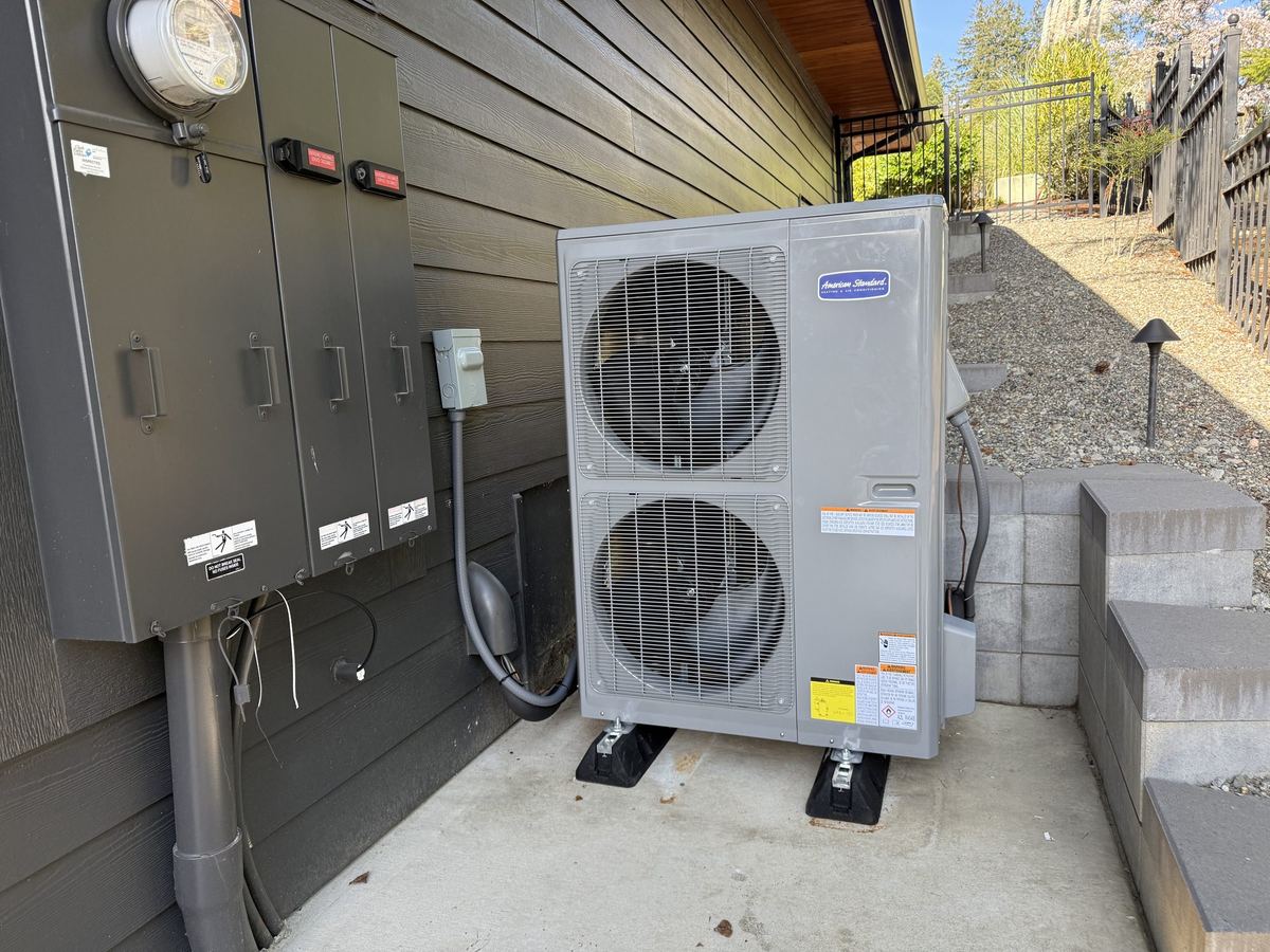 A new American Standard outdoor unit installed beside the electrical panel
